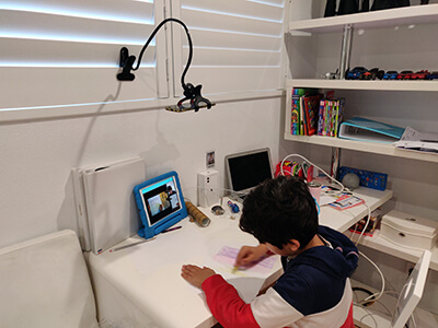 A kid in a virtual art class, using the Classnika app to communicate with his teacher